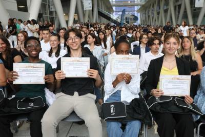 Collégiens assis sur des chaises devant la tribune à l'Hôtel du Département. Le premier rang montre leurs diplômes. - Agrandir l'image 2 sur 3, fenêtre modale