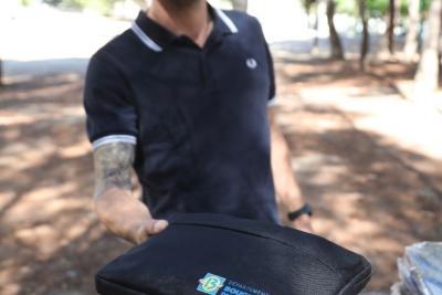 Gros plan sur un kit de fournitures scolaires porté par un agent des écoles - Agrandir l'image 10 sur 23, fenêtre modale