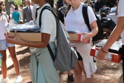 Collégiens tenant dans leurs mains les kits de fournitures et ordinateurs offerts par le Département - Agrandir l'image 11 sur 23, fenêtre modale