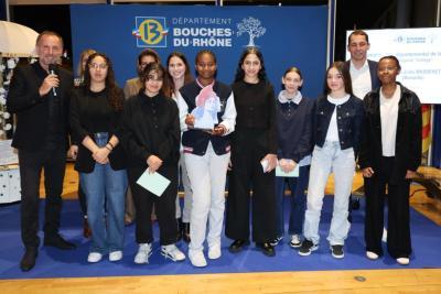 Groupe de jeunes participants posant sur une scène avec un fond bleu portant le logo « Département Bouches-du-Rhône », certains tenant un trophée en forme de silhouette colorée. - Agrandir l'image 5 sur 6, fenêtre modale