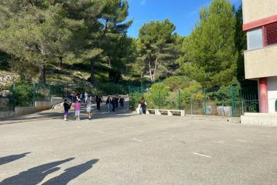 Des personnes marchent sur une allée pavée bordée de végétation et d’arbres, dans un environnement qui semble faire partie du même complexe scolaire. - Agrandir l'image 5 sur 6, fenêtre modale