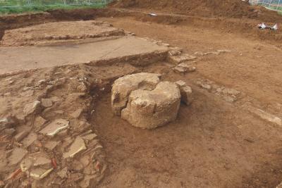 Bloc de pierre massif au centre d’un site archéologique, entouré de vestiges et de sols excavés - Agrandir l'image 3 sur 5, fenêtre modale