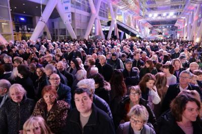 Foule rassemblée dans un hall éclairé en violet et bleu pour un événement officiel - Agrandir l'image 15 sur 20, fenêtre modale