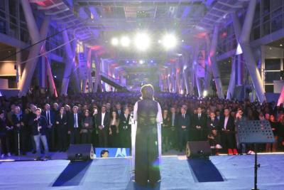 Martine Vassal vue de dos sur scène face à une foule nombreuse dans un grand hall éclairé - Agrandir l'image 18 sur 20, fenêtre modale