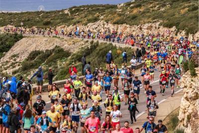 Grande foule de coureurs participant au semi-marathon Marseille-Cassis sur une route sinueuse bordée de rochers, avec vue sur la mer Méditerranée et les îles au loin. - Agrandir l'image 6 sur 12, fenêtre modale