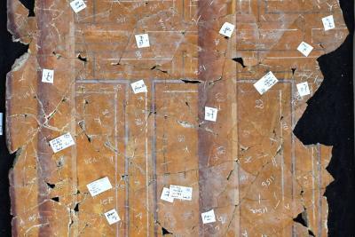 reconstitution d'une fresque, éclats par éclats, représentant des colonnes soutenant un mur - Agrandir l'image 9 sur 14, fenêtre modale