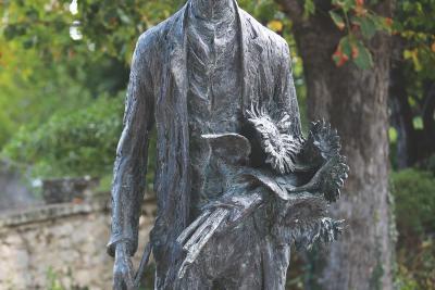 Statue extérieure représentant une personne tenant des tournesols dans une main et des feuilles dans l’autre. Elle est placée dans un environnement verdoyant, probablement un jardin ou un parc. - Agrandir l'image 2 sur 6, fenêtre modale